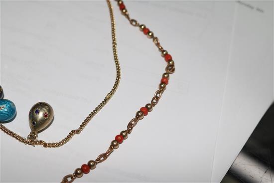 A 9ct gold necklace hung with four egg shaped charms and a 9ct gold and coral bead necklace.